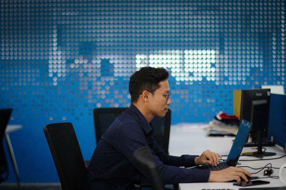 Software engineering leadership team collaborating in office with laptops
